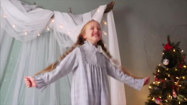 两个辫子的可爱女孩跳到床上 玩得很开心 圣诞节期间 — 图库视频影像