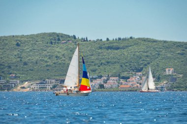 Güneşli bir yaz gününde bir köyle Adriyatik Denizi 'nde yelken açmak. Denizde yelkenli yarışı.