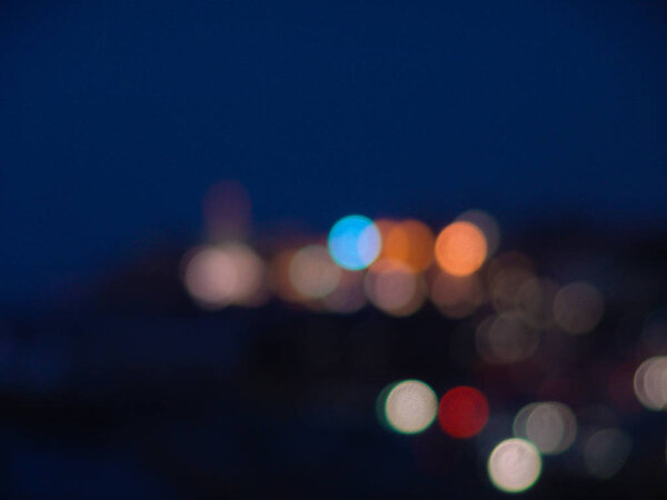 Night city lights bokeh of defocused vivid colorful circles of light in blue hour background in Jaffa, Israel
