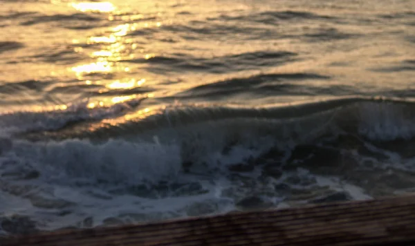 Onda che si schianta in mare, al tramonto con gocce d'acqua spruzzando un — Foto Stock