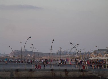 Tel Aviv'in bağlantı noktası boardwalk uzak görünümünü birçok pe ile gün batımında