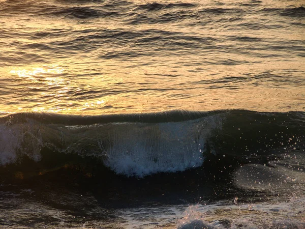 Våg kraschar i havet, vid solnedgången med vatten droppar stänker en — Stockfoto
