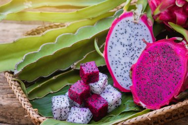 Dragon meyve dilimleri kare bir kesik ve yarım kesim dragon meyve ağacı yaprak yeşil hizmet veren üzerinde