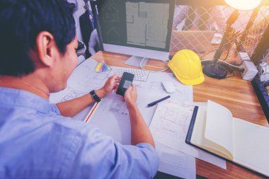 Ofiste masasında inşaat sahasında mimari proje için plan üzerinde çizim çalışma mimarileri