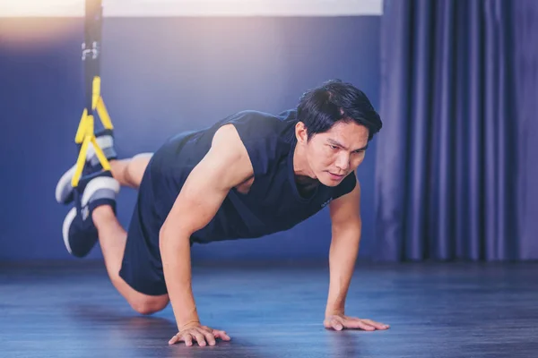 Fit человек делает доску упражнения для спины позвоночника отжимания с веревкой фитнес-ремни в тренажерном зале Лицензионные Стоковые Изображения