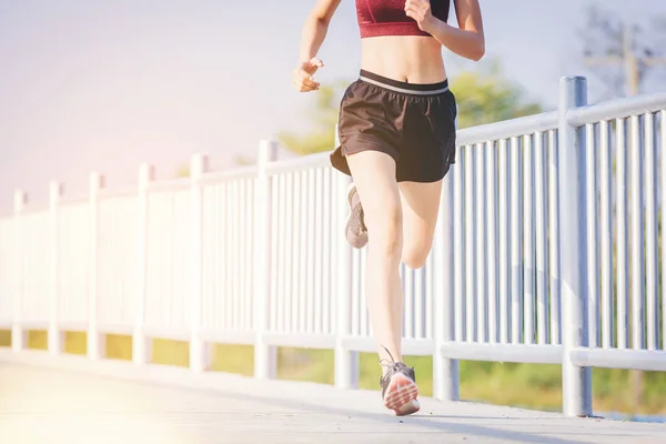 Женщина, бегущая по дороге. Фитнес-бегунья во время тренировки на свежем воздухе Лицензионные Стоковые Фото