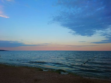 Güzel parlak mavi deniz manzarası: gökyüzü, bulutlar, su, dalgalar, kum, rüzgar. Harika tatil ve seyahat 