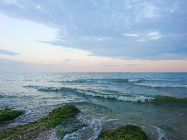Güzel parlak mavi deniz manzarası: gökyüzü, bulutlar, su, dalgalar, kum, rüzgar. Harika tatil ve seyahat 
