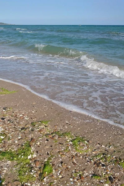 Güzel parlak mavi deniz manzarası: gökyüzü, bulutlar, su, dalgalar, kum, rüzgar. Harika tatil ve seyahat 