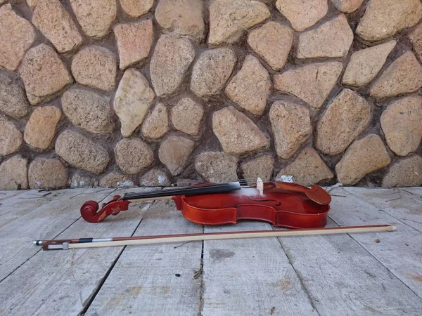 New violin and bow near the stone wall