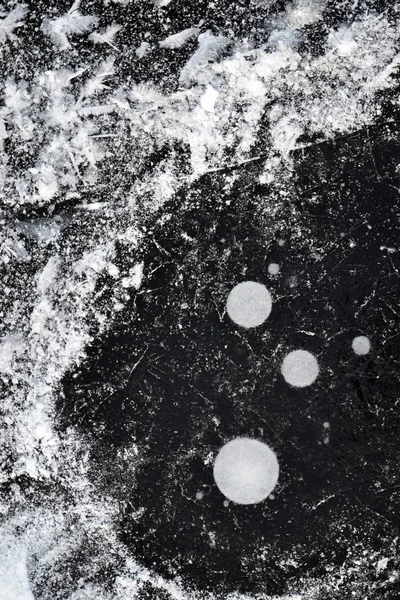 Kar ve hava kabarcıkları kış zaman donmuş gölde buz altında. Renkler beyaz, siyah. Rusya, ostrov, pskov