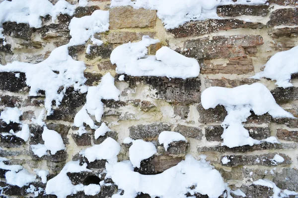 Antik kale duvar kireçtaşı yaptı ve taş beyaz karla kaplı. Rusya, Izborsk.