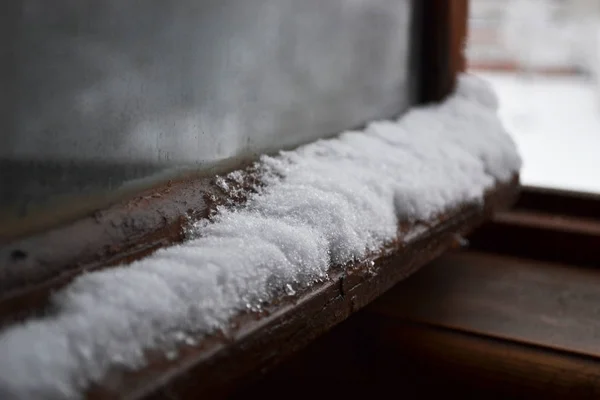 Kar yağışı kışın ahşap pencere çerçevesi üzerinde karla karışık karışık yatay fotoğraf, Rusya, Pskov. renkler beyaz, kahverengi, siyah