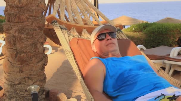 Jeune Homme Dans Une Casquette Soleil Repose Dans Hamac Sur — Video