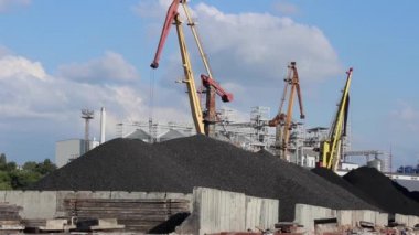 Rıhtımdaki limanda, büyük vinçler kömür ve kargo boşaltıyorlar.