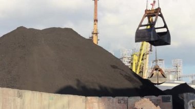 Portal vinçler limanda büyüktür; vinçler büyük malzeme ve kömür yükler. Limandaki vinçlerin işi.