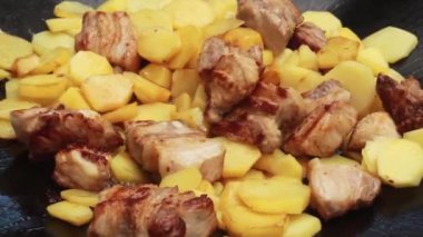 Büyük bir aile ve doğadaki misafirler için yaz güneşli bir günde büyük bir tavada et ve şenlik ateşiyle lezzetli patatesler kızartıyoruz.