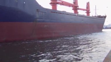 Büyük kuru bir kargo gemisi ticari limana ve rıhtımdaki kırlara giriyor. Rıhtımın manzarası. Yakın plan.