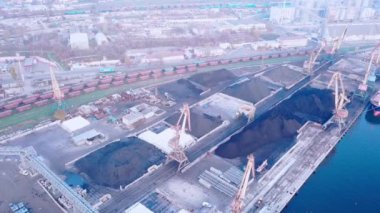 Sivastopol limanının panoramik görüntüsü. Rıhtımda büyük kömür kargoları var. Vagonlar yükleme için bekliyor. Portal vinçler çalışıyor. Gemi rıhtımda boşaltılıyor. Kuş bakışı. Drone. Kuadrokopter.