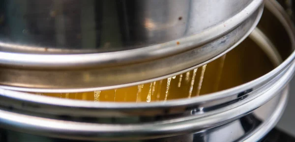 Strain the poured honey through a sieve. How to Harvest Honey. Filtering raw honey, France