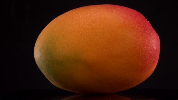 Свежие желтые фрукты манго соляные на черном фоне, поворотный стол — стоковое видео