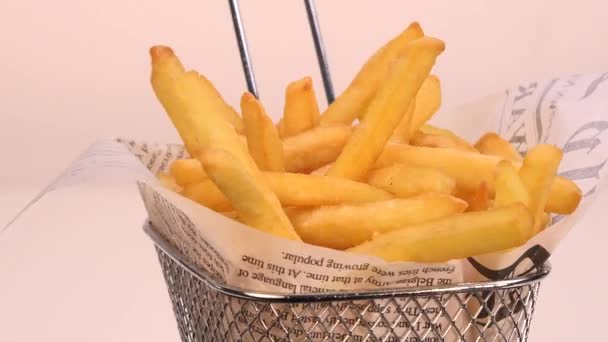 Franse frietjes in een kleine ijzeren mand op draaitafel frituren — Stockvideo