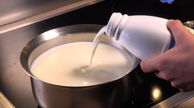 Doğal organik süt pişir, sütü tencerede kaynat, sütü tavaya dök.