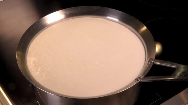 Natuurlijke biologische melk koken, kook de melk in potten, melk die is bezig met overloop, overlopend van melk — Stockvideo