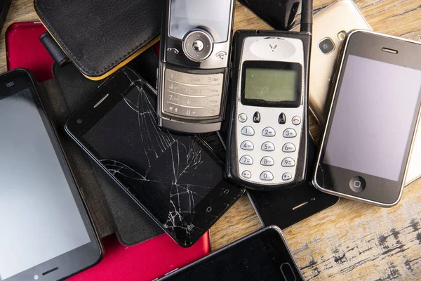 Old, broken and obsolete cellphone on wood background — Stock Photo, Image