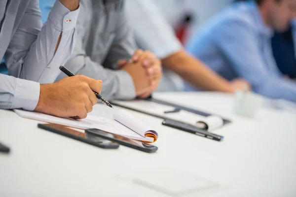 Mann macht sich Notizen, schreibt bei der Arbeit an einem Papier — Stockfoto