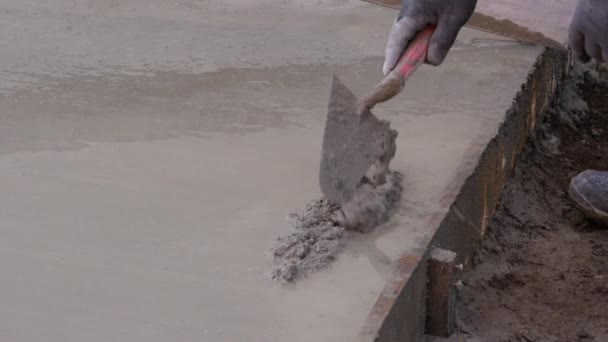 Каменная кладка, человек выравнивает бетонную плиту для дома терраса — стоковое видео