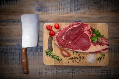 Tahtadaki çiğ T-Bone bifteği ızgaraya hazır. 