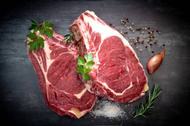 Tahtadaki çiğ T-Bone bifteği ızgaraya hazır. 