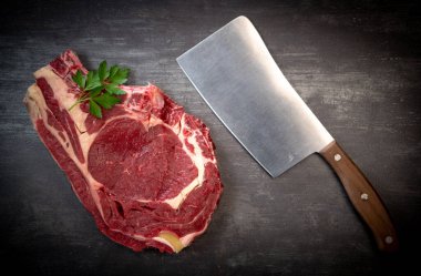 Tahtadaki çiğ T-Bone bifteği ızgaraya hazır. 