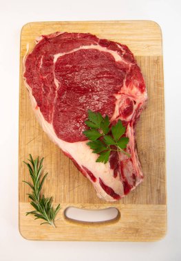 Tahtadaki çiğ T-Bone bifteği ızgaraya hazır. 