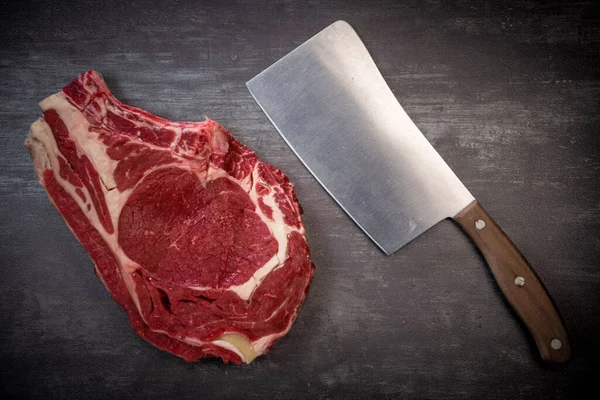 Bife de osso T cru em tábua de madeira preparada para grelhar — Fotografia de Stock