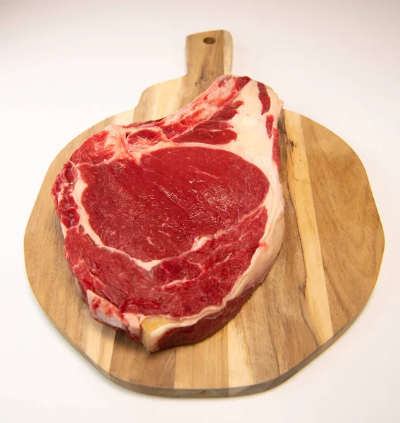 Surowy stek T Bone na drewnianej desce przygotowanej do grillowania — Zdjęcie stockowe