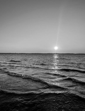 Güneş Arcachon 'da Plage Peirere' de batarken, altın ışınlar ıslak kumu yansıtıyor, sakin ve sakin bir atmosfer yaratıyor sakin bir sahil yürüyüşü için mükemmel.