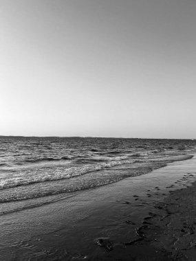 Güneş Arcachon 'da Plage Peirere' de batarken, altın ışınlar ıslak kumu yansıtıyor, sakin ve sakin bir atmosfer yaratıyor sakin bir sahil yürüyüşü için mükemmel.