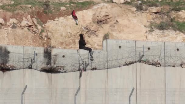 巴勒斯坦阿拉伯儿童男孩挥舞着国旗在安全墙上的铁丝网上 耶路撒冷 以色列 — 图库视频影像