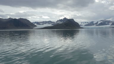 Okyanus su yakınında karla kaplı buzul dağlarının doğal görünümü