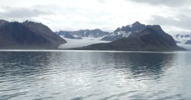 Okyanus su yakınında karla kaplı buzul dağlarının doğal görünümü