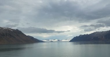 Okyanus su yakınında karla kaplı buzul dağlarının doğal görünümü