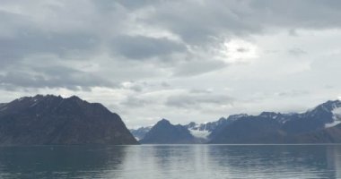 Okyanus su yakınında karla kaplı buzul dağlarının doğal görünümü