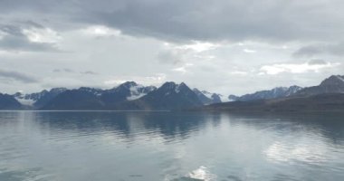 Okyanus su yakınında karla kaplı buzul dağlarının doğal görünümü