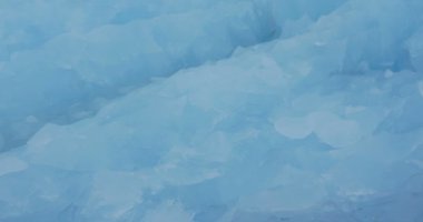 Büyük mavi buzdağı kayan görünümü kapatın ve buz parçaları 