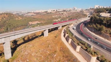 Kudüs girişinde, Kudüs 'teki büyük köprü anteninde tren. Kudüs' teki demiryolu köprüsünün üzerinden geçen kırmızı trenin Drone görüntüleri.