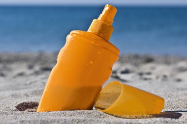 Sahilde deniz kum güneş kremi şişe