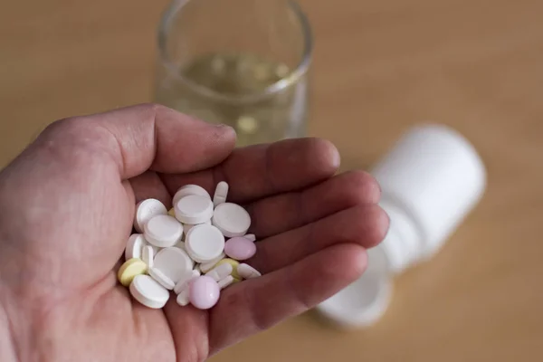 adam bir avuç hap içmeye gidiyor