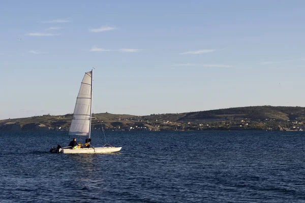 man walking on a sailing boat along the seashore